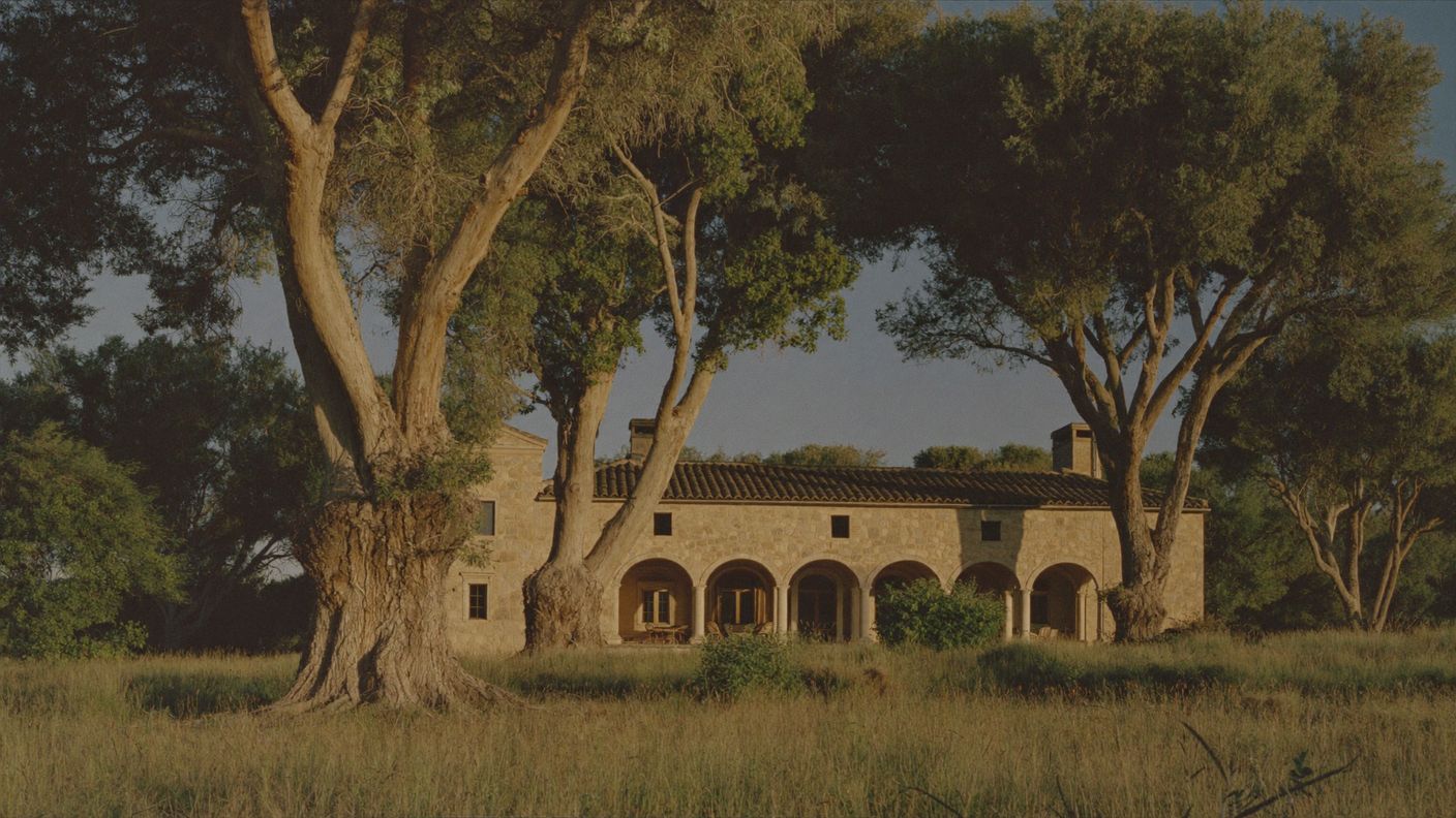 Cortijo restaurado entre encinas en la dehesa de Cáceres al atardecer